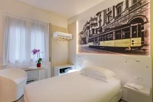 a bedroom with a white bed and a picture of a tram at Kleos Hotel Milano Città Studi by Kleos Group Collection in Milan +172 photos