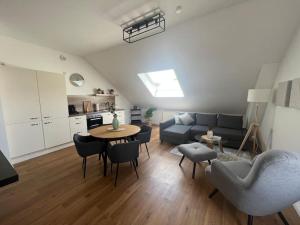 uma sala de estar com um sofá, uma mesa e cadeiras em DLC: exklusive Suite im Zentrum em Bad Pyrmont
