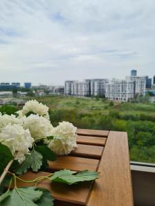 a wooden bench with a bouquet of white flowers at Onix View 37, Premium Parking in Bucharest