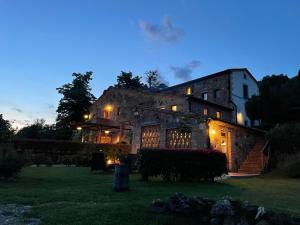 モンテプルチャーノにあるGodioloの夜の灯り付きの大きな石造りの家