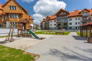 ein Spielplatz mit Rutsche und Schaukel in der Unterkunft Apartament Kryształ Górski - Stone Hill in Szklarska Poręba
