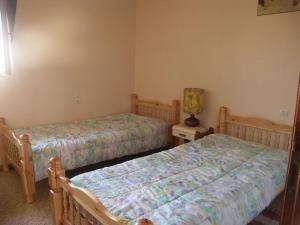 1 dormitorio con 2 camas y mesita de noche con lámpara en Le pin franc, en Azur
