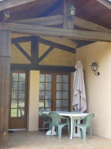 un patio con mesa, sillas y sombrilla en Le pin franc, en Azur
