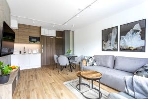 salon z kanapą i stołem w obiekcie Apartament Kryształ Górski - Stone Hill w Szklarskiej Porębie