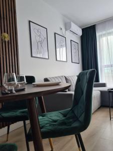 ein Wohnzimmer mit einem Tisch und grünen Stühlen in der Unterkunft Onix View 37, Premium Parking in Bukarest