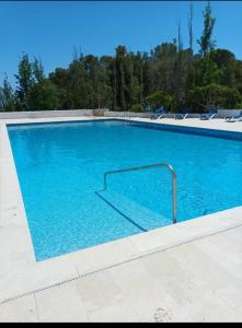 a large blue swimming pool with a metal rail at La calma de Tossa in Girona