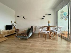 sala de estar con mesa y sofá en La calma de Tossa, en Girona