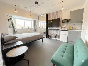 1 dormitorio con cama, sofá y cocina en Cosy Bright Studio Apartment Close to Wembley Stadium en Londres