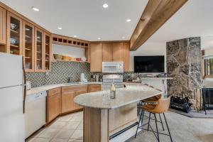 a kitchen with wooden cabinets and a white refrigerator at Laurelwood Condominiums 105 in Snowmass Village