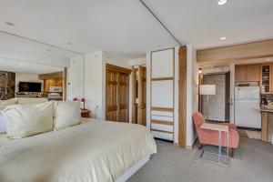 a bedroom with a large white bed and a chair at Laurelwood Condominiums 105 in Snowmass Village