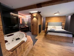 una camera con letto e vasca da bagno accanto a un letto di Hotel Rio Bianco a Panchia