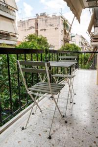 een stoel op een balkon naast een hek bij The Athenian Hideaway 2- Bedroom apartment in Thiseio in Athene