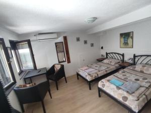 a room with two beds and a desk and a table at Villa Dudinka in Ohrid