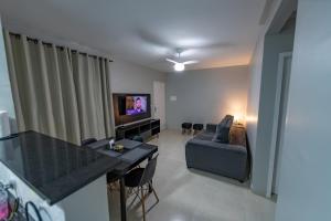 - un salon avec un canapé et une table dans l'établissement Lindo apartamento 2 quartos com wifi, à Rio das Ostras