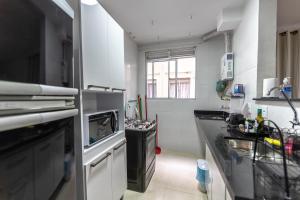 a small kitchen with a sink and a dishwasher at Lindo apartamento 2 quartos com wifi in Rio das Ostras