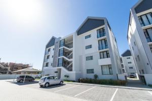 Summerstrand10 on Bellamare near the Beachfront的停在建筑物前停车场的汽车