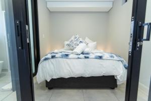 1 dormitorio con cama y espejo en 10 on Bellamare near the Beachfront en Summerstrand