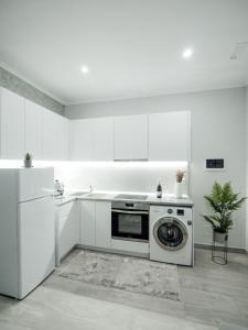 a white kitchen with a washing machine in it at Dionis House in Shkodër