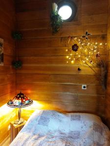 1 dormitorio con pared de madera, cama y lámpara en Les jardins d'Isa en Tourves