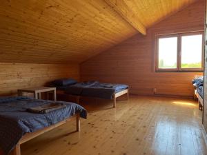 Habitación con 2 camas en una cabaña de madera en Vītolu nams - atpūta ar saunu un makšķerēšanu, en Durbe
