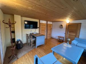 ein Wohnzimmer mit einem Tisch und einem TV an der Wand in der Unterkunft Vītolu nams - atpūta ar saunu un makšķerēšanu in Durbe