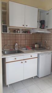 a kitchen with white cabinets and a sink at Armenistis apartment in Armenistis