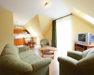 a living room with two couches and a tv at Centrum Apartmanház in Hévíz