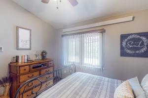 ein Schlafzimmer mit einem Bett, einer Kommode und einem Fenster in der Unterkunft Tumble Inn in Rapid City