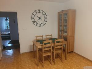 a dining room with a table and a clock on the wall at Mieszkanie Żywiec in Żywiec