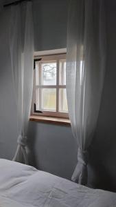um quarto com uma cama e uma janela em A cozy cottage where you can enjoy the peace of the countryside em Salacgrīva