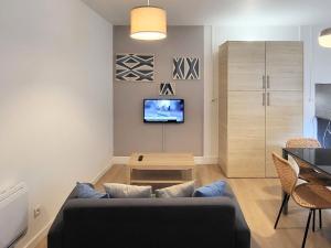 a living room with a couch and a table at Appartement 1 Chambre, cuisine, coin salon, salle de bain in Saint-Claude