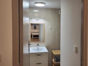 a bathroom with a sink and a mirror at Appartement 1 Chambre, cuisine, coin salon, salle de bain in Saint-Claude
