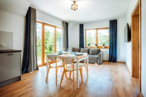 a kitchen and living room with a table and chairs at Apartamenty Widok Tatr in Zakopane