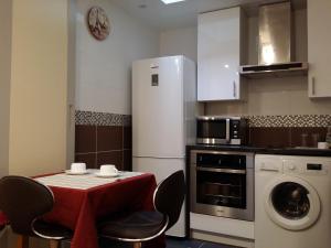 a kitchen with a table and a white refrigerator at Hôtel Paris Gambetta in Paris