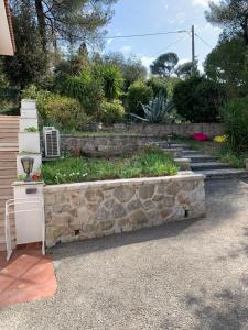a stone retaining wall with a garden in a yard at Brise des Pins in Le Cannet