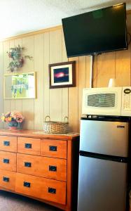 a kitchen with a microwave on top of a refrigerator at Patras Grand Beach Motel in Old Orchard Beach