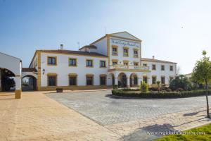a large white building with a driveway in front of it at Hospedium Hotel Cortijo Santa Cruz in Villanueva de la Serena