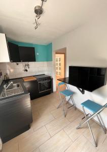 eine Küche mit einer Spüle sowie einem Tisch und Stühlen in der Unterkunft Ruhige Ferienwohnung im Saarland in Schiffweiler