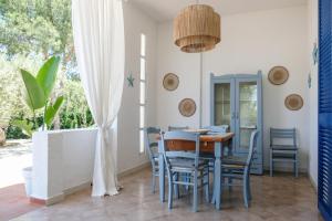 a dining room with a table and chairs and a window at Pugliamandia in Monopoli