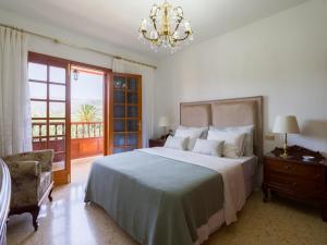 een slaapkamer met een groot bed en een kroonluchter bij CASA LOLINA in Teror