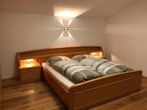 a bed in a room with a light on the wall at Ferienhaus Leitner in Tires