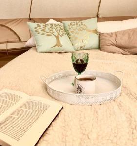 bandeja con una taza de café y un libro en la cama en Tempus Te Glamping Lääne - Virumaal, 