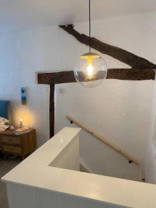 een kamer met een trap en een licht aan een plafond bij 1750's cottage with open fire and beams in Upholland