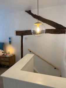 a room with a staircase and a light hanging from a ceiling at 1750's cottage with open fire and beams in Upholland