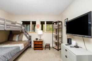 een slaapkamer met een stapelbed en een flatscreen-tv bij Alyeska Slopeside in Girdwood