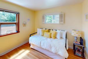 Un dormitorio con una cama con paredes amarillas y una ventana en Wallingford Heights en Seattle