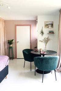 a room with a table and chairs and a bed at Bed & Bakkie Het Lamsoor Texel in 't Horntje +13 photos