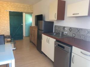 uma cozinha com um frigorífico e uma bancada em Maison de ville atypique em Le Molay-Littry