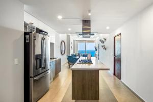 a kitchen with a refrigerator and a counter top at Harbor 171 Oceanfront Residences #13011 in Puerto Vallarta
