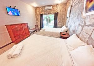 ein Hotelzimmer mit 2 Betten und einem TV in der Unterkunft Surf Ranch Hotel & Resort in San Juan del Sur